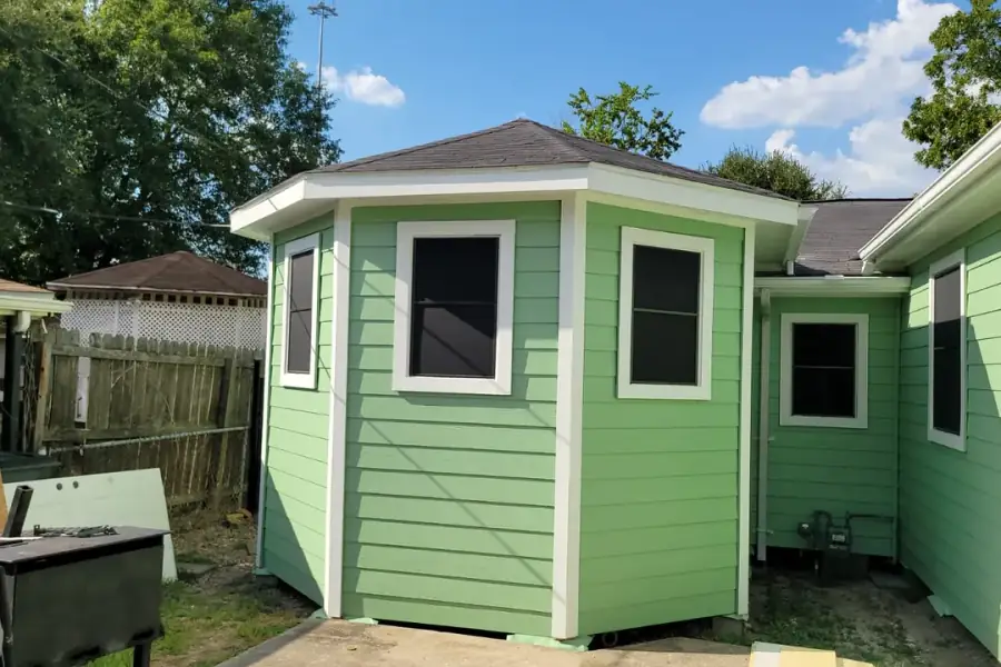 Finished green siding, white trim and new windows on a Houston house